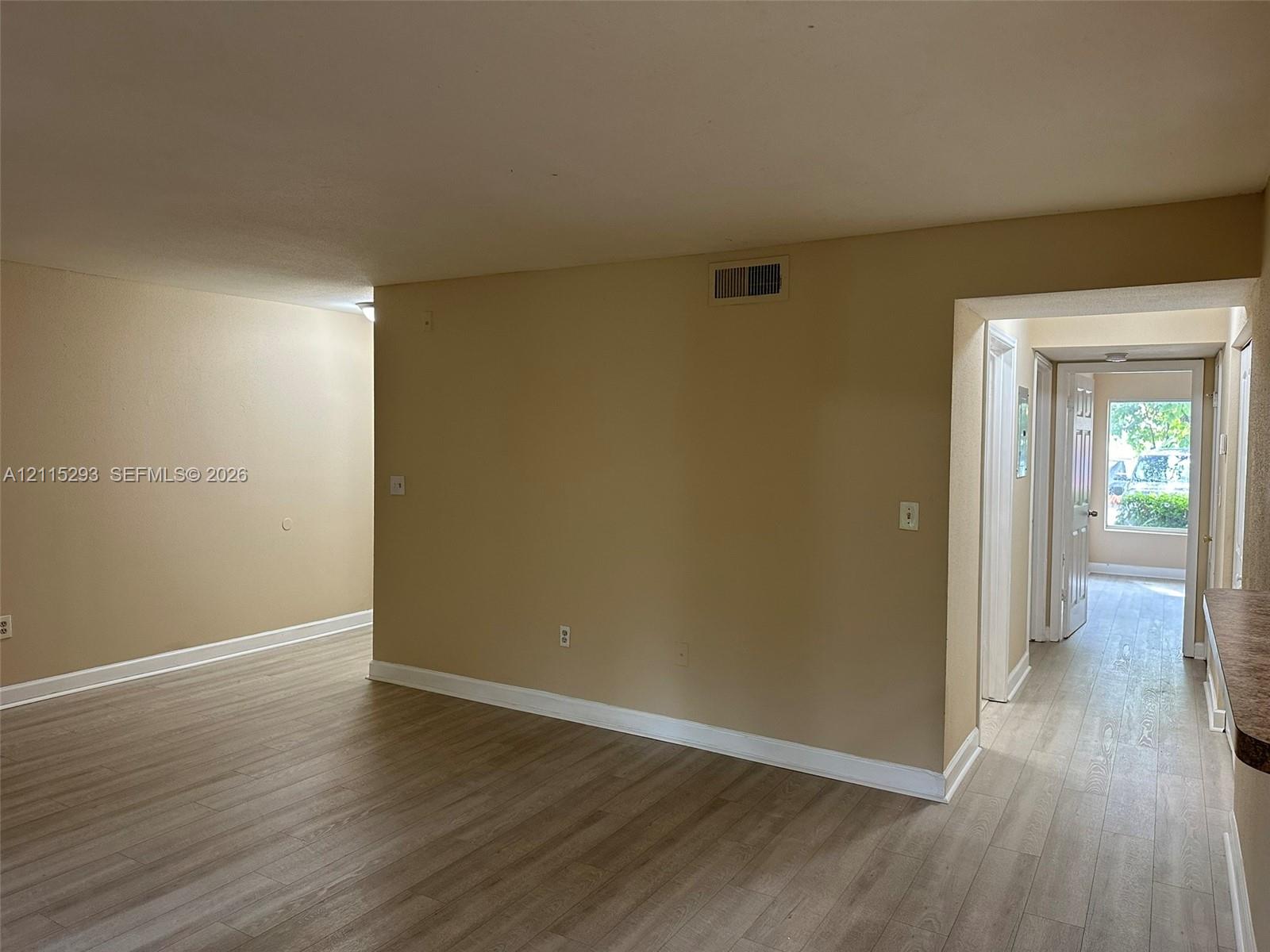 Interior featuring wood-finish flooring, neutral wall paint, and white trim accents