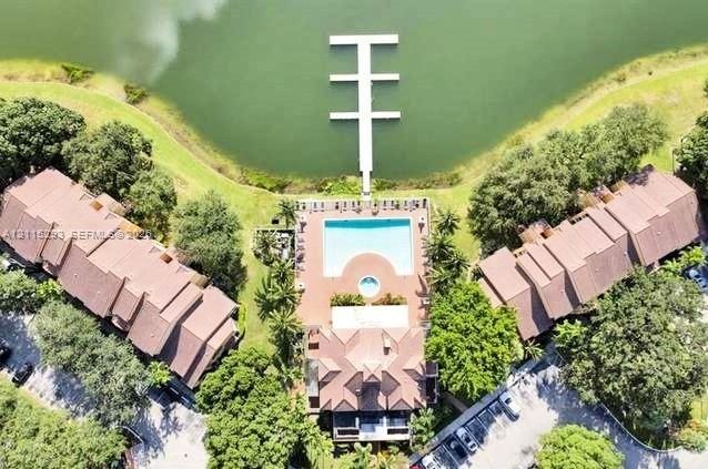 Waterfront property featuring a private multi-slip dock, a swimming pool, a separate spa, and paved grounds