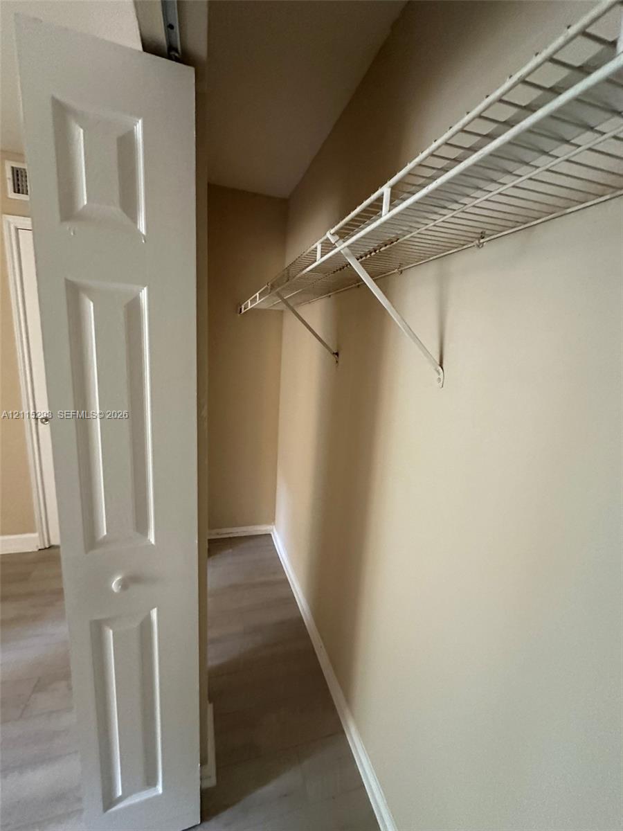 Storage space featuring bi-fold panel doors and wire shelving