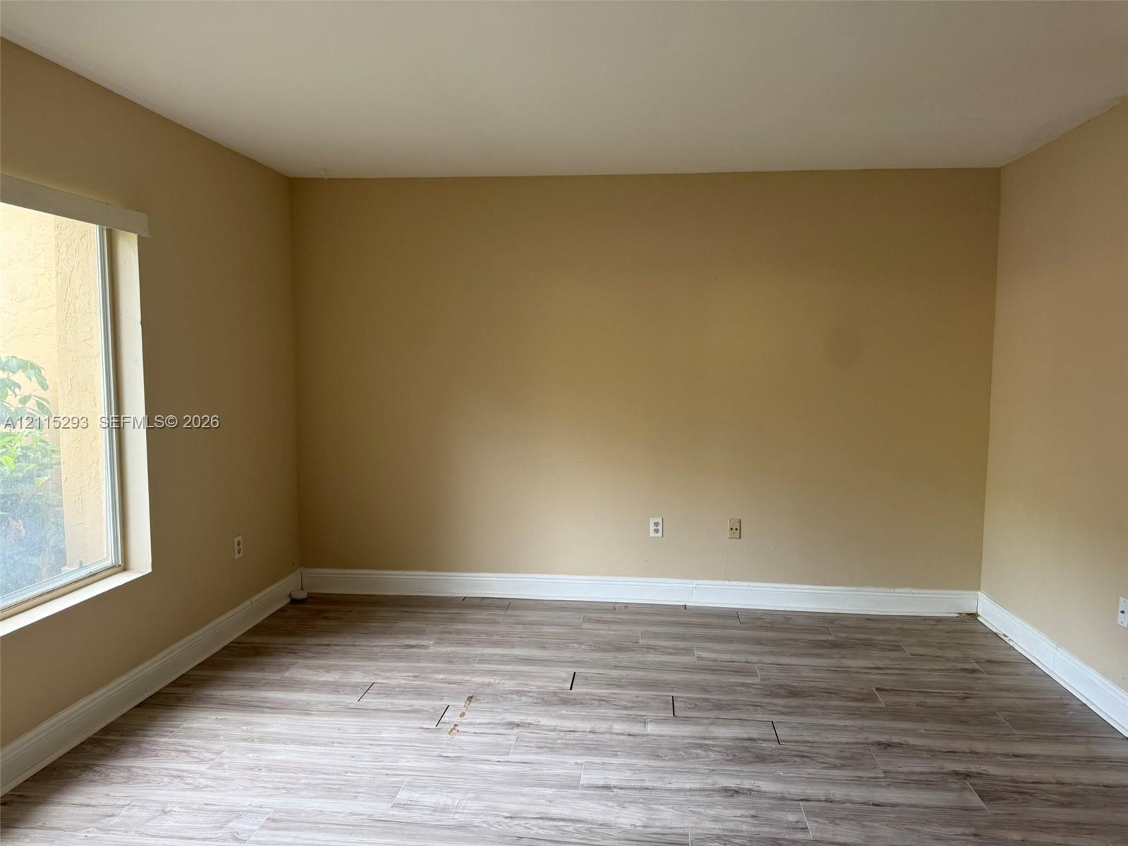 Interior room featuring wood-finish tile flooring and a large window