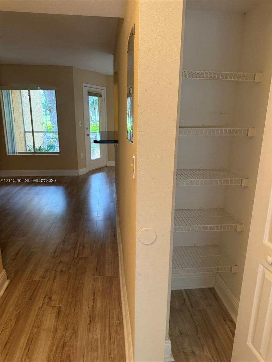 Built-in storage closet with wire shelving and wood-finish flooring