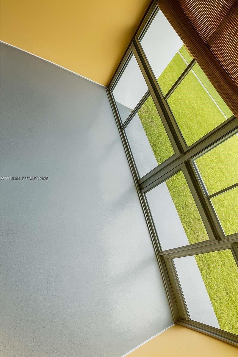 Floor-to-ceiling multi-pane windows with thin metal framing, integrated window treatment, and smooth-finish wall surfaces
