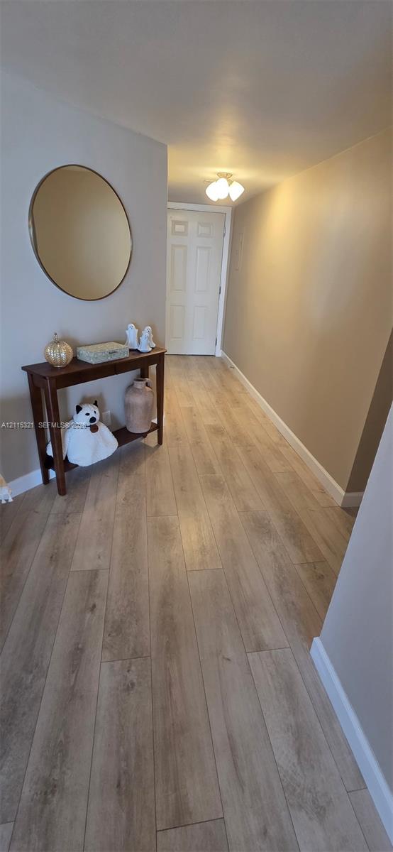 Neutral-toned interior featuring wood-finish flooring and a multi-panel door
