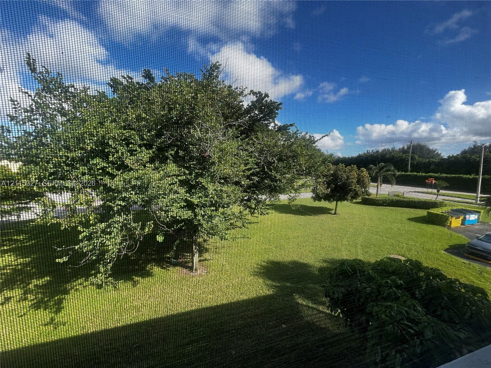 Expansive outdoor grounds featuring mature trees and established lawn areas