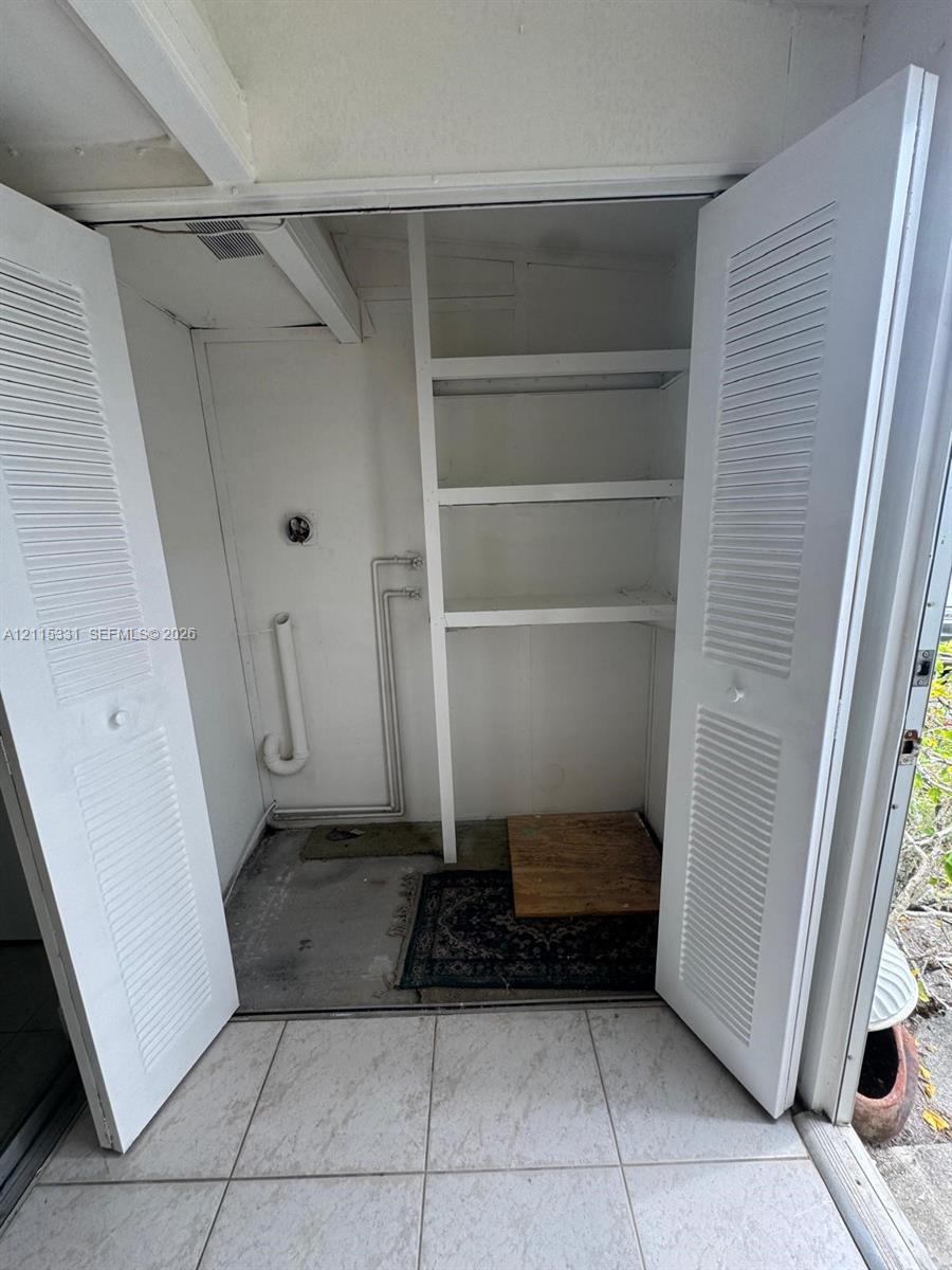 Laundry closet with stacked washer and dryer 1 year old