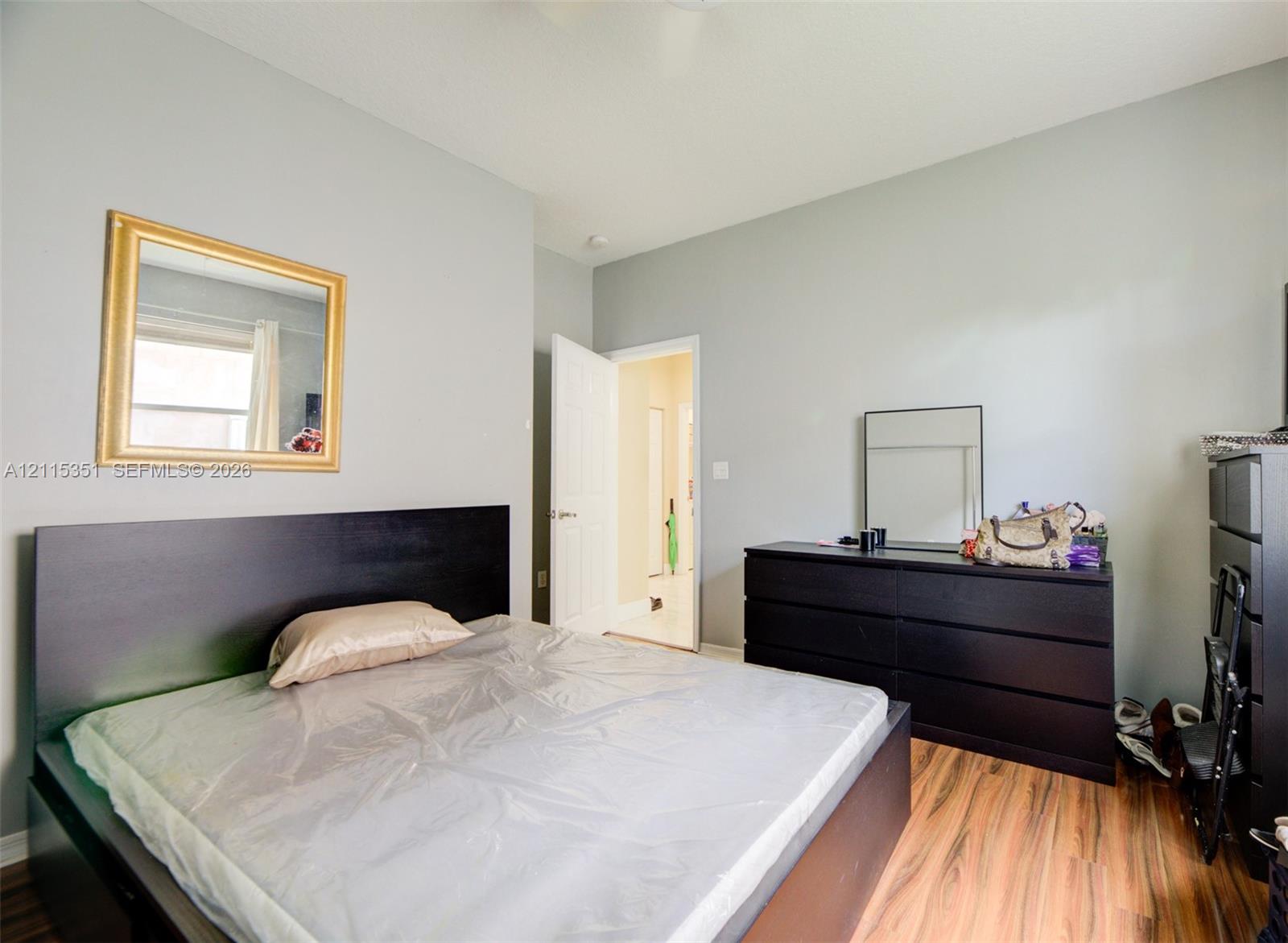 Neutral-toned interior walls featuring wood-finish flooring and a single-panel interior door