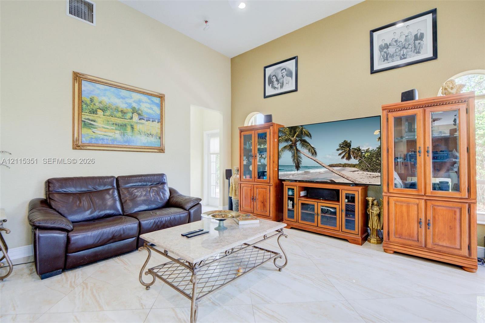 Vaulted ceilings, arched windows, and light-toned tile flooring