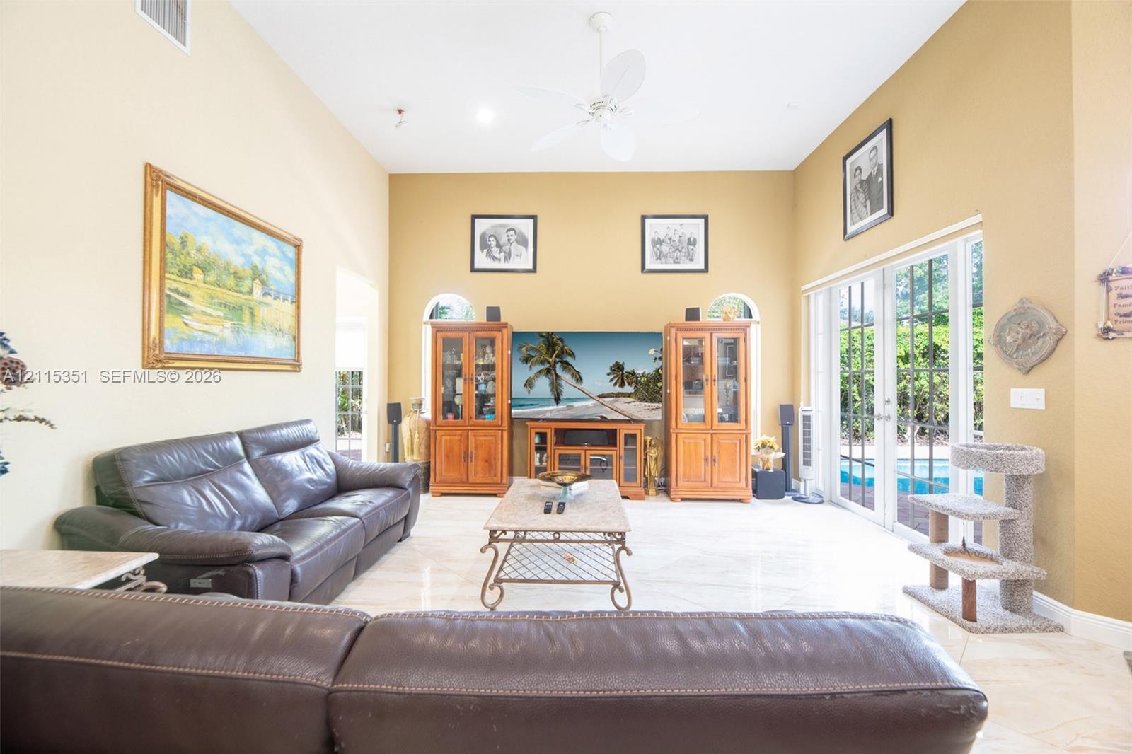 Vaulted ceilings, large-format tile flooring, dual arched windows, and multi-pane glass French doors
