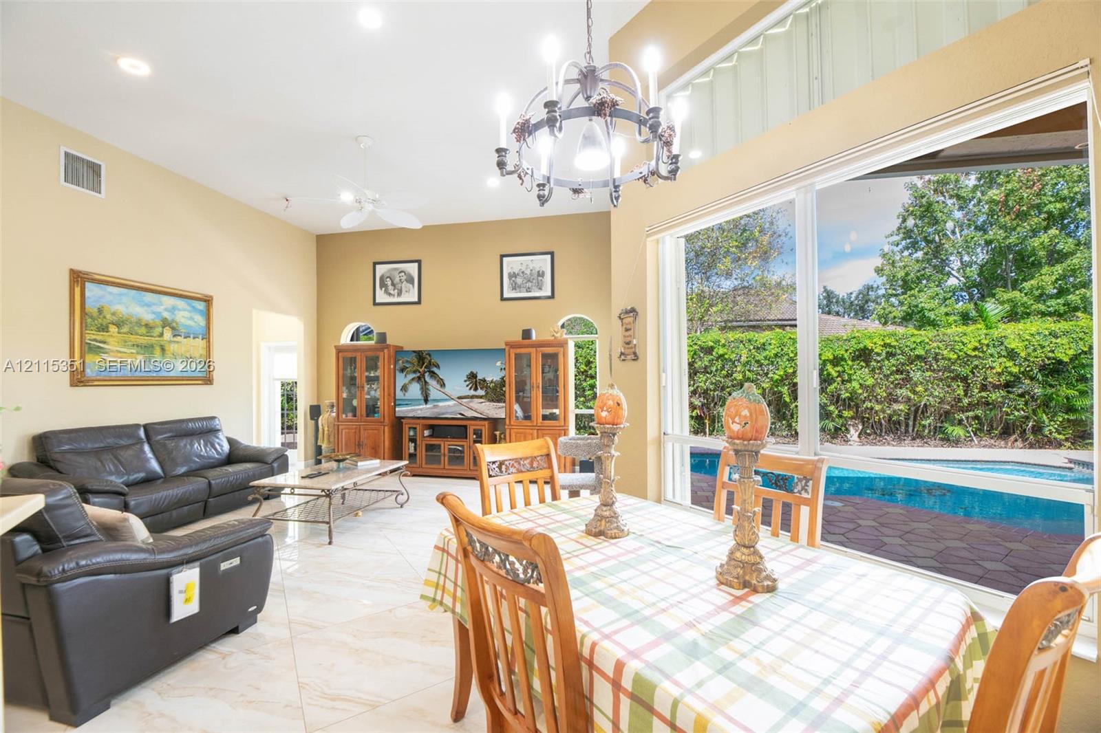Vaulted ceilings, large-format tile flooring, oversized picture windows, and a multi-arm chandelier