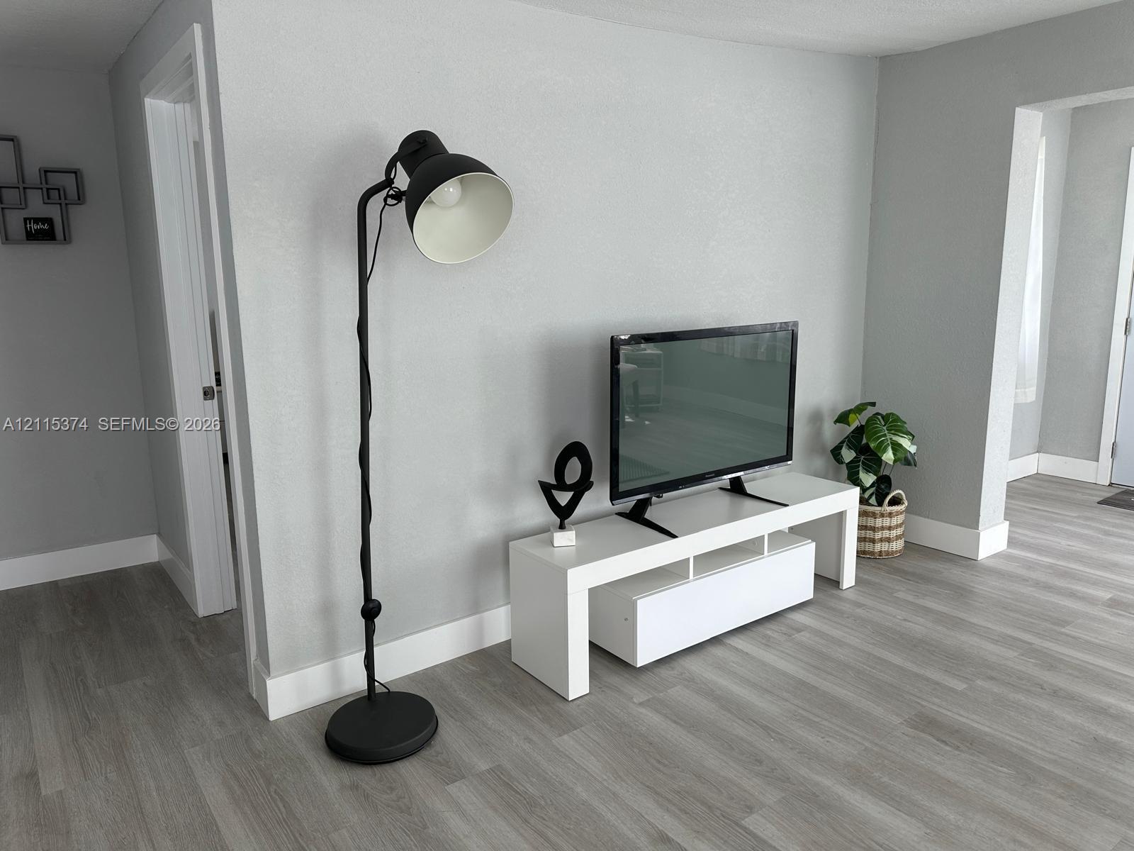 Neutral-toned walls paired with continuous wood-finish flooring throughout the space