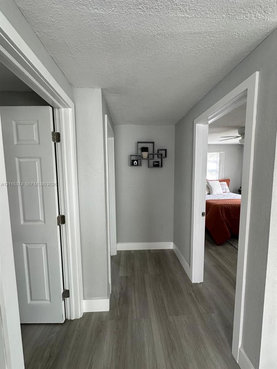 Interior hall featuring gray wall paint, white door trim, and wood-finish flooring