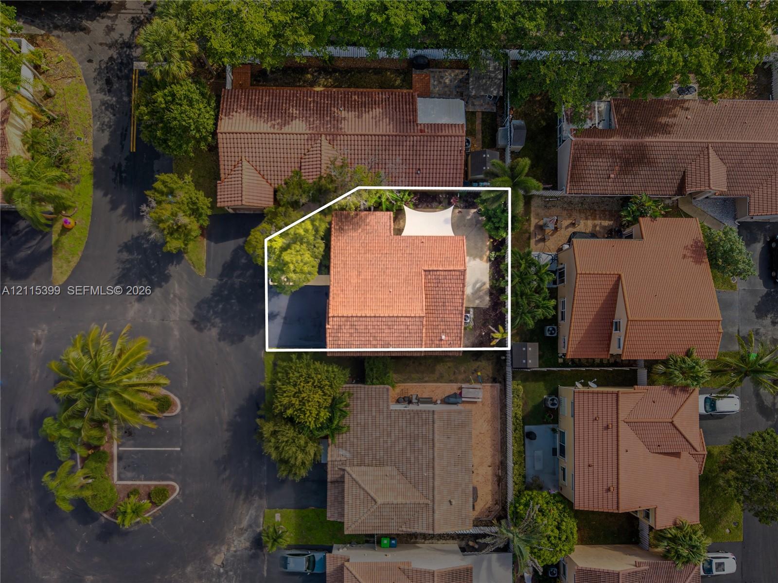 Aerial perspective featuring a tile roof, paved driveway, and rear patio area
