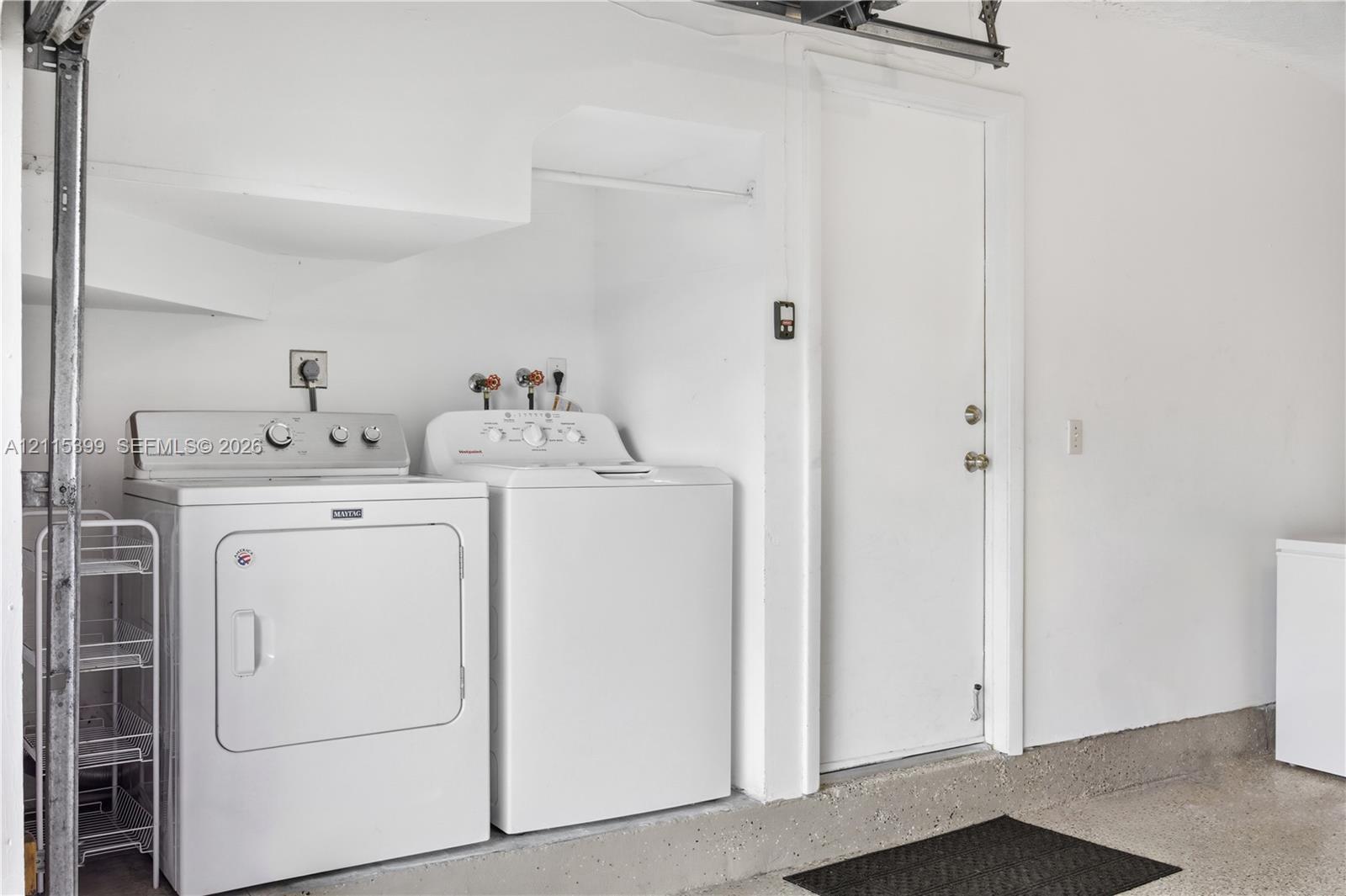 Laundry area featuring a dedicated recessed hookup space, an overhead built-in clothing rod, and a swinging utility door