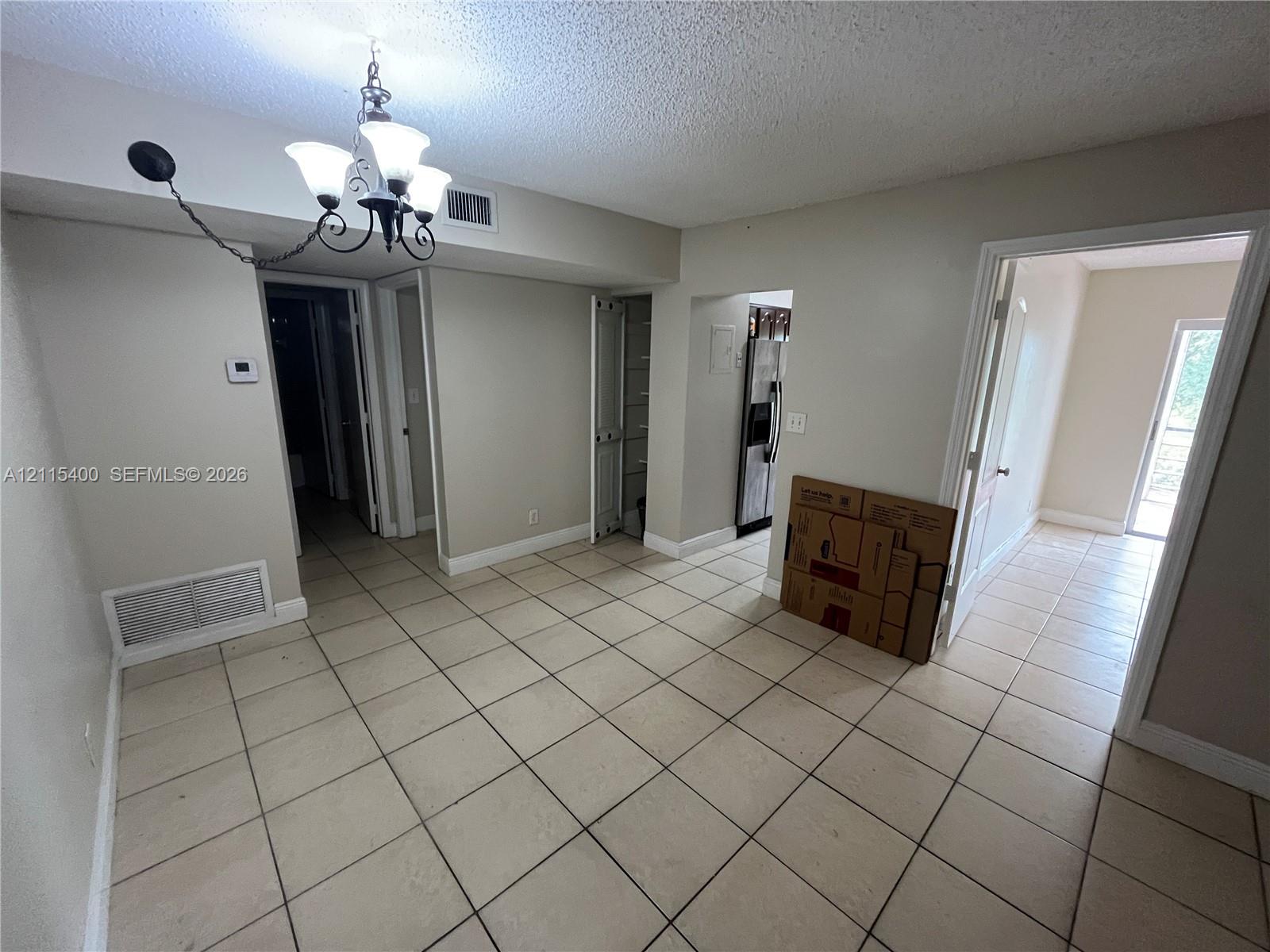 Ceramic tile flooring, built-in storage cabinetry, and a multi-arm overhead light fixture