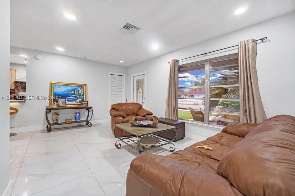Polished tile flooring, recessed ceiling lighting, and large window with multi-pane glass