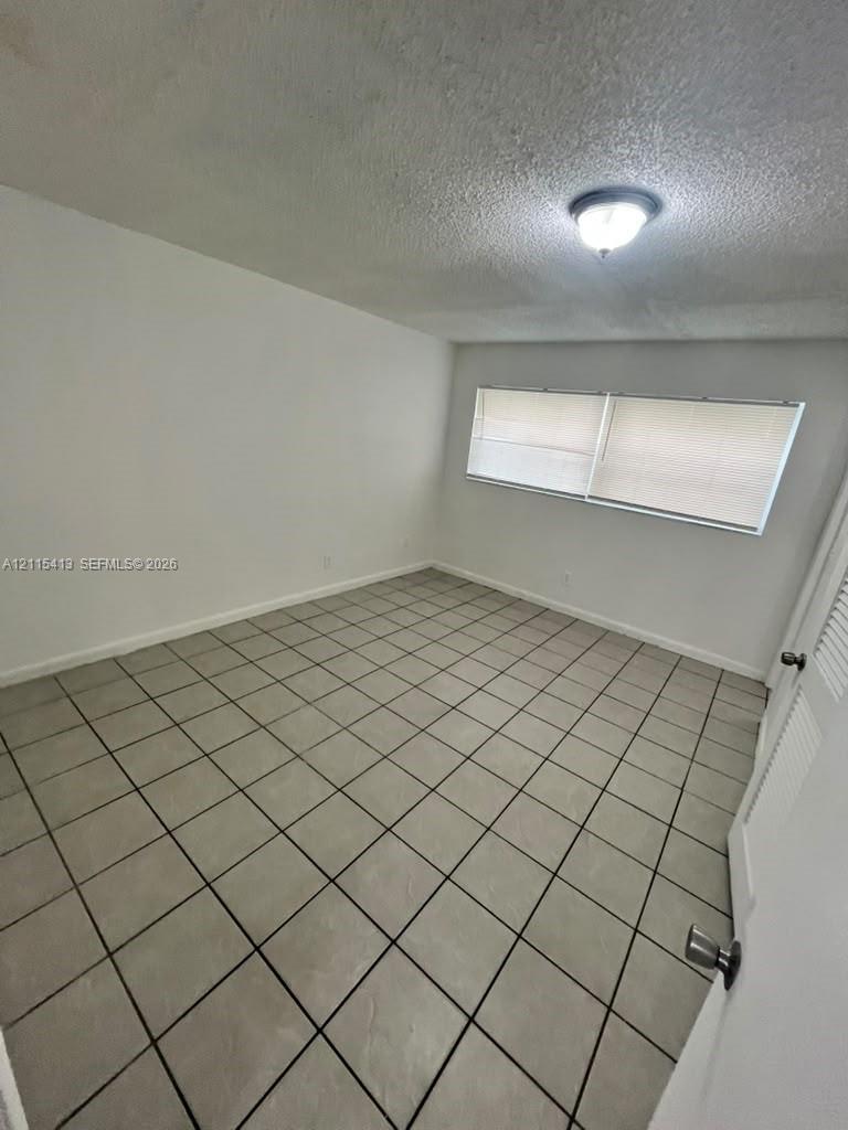 Neutral-toned ceramic tile flooring, semi-flush mount ceiling lighting, and horizontal window blinds