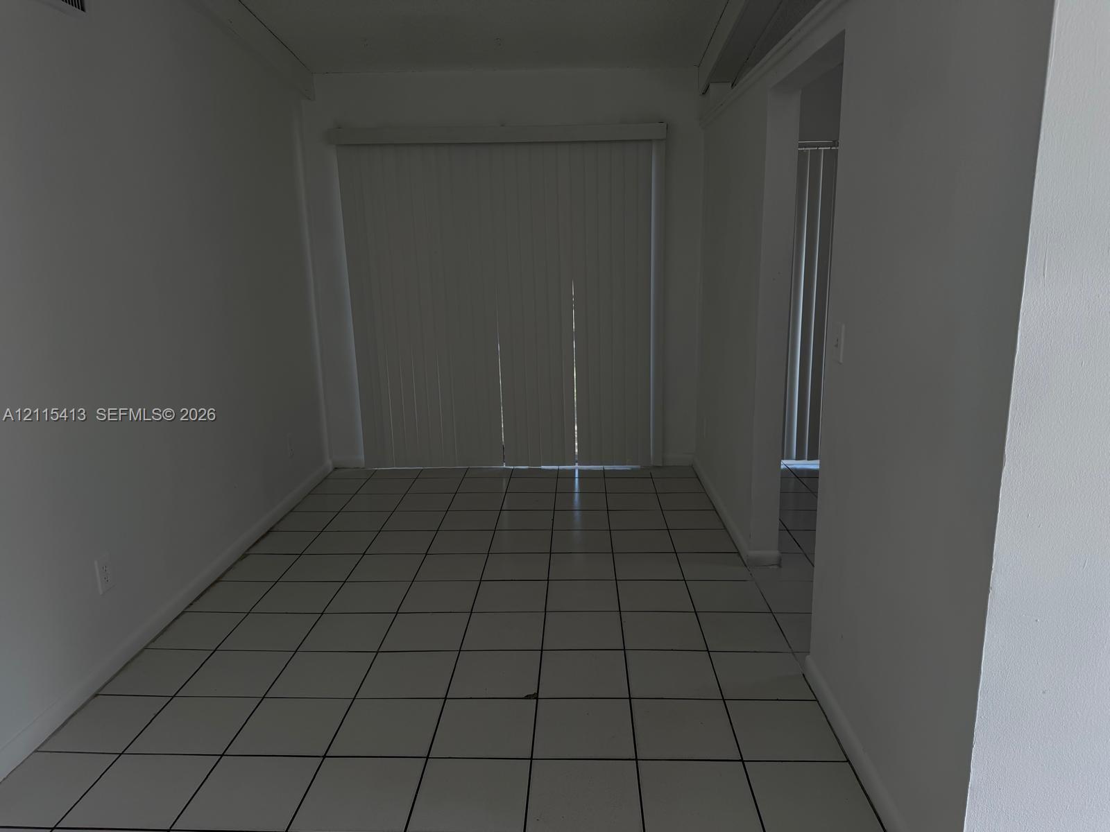 Interior space featuring ceramic tile flooring and floor-to-ceiling vertical sliding glass doors