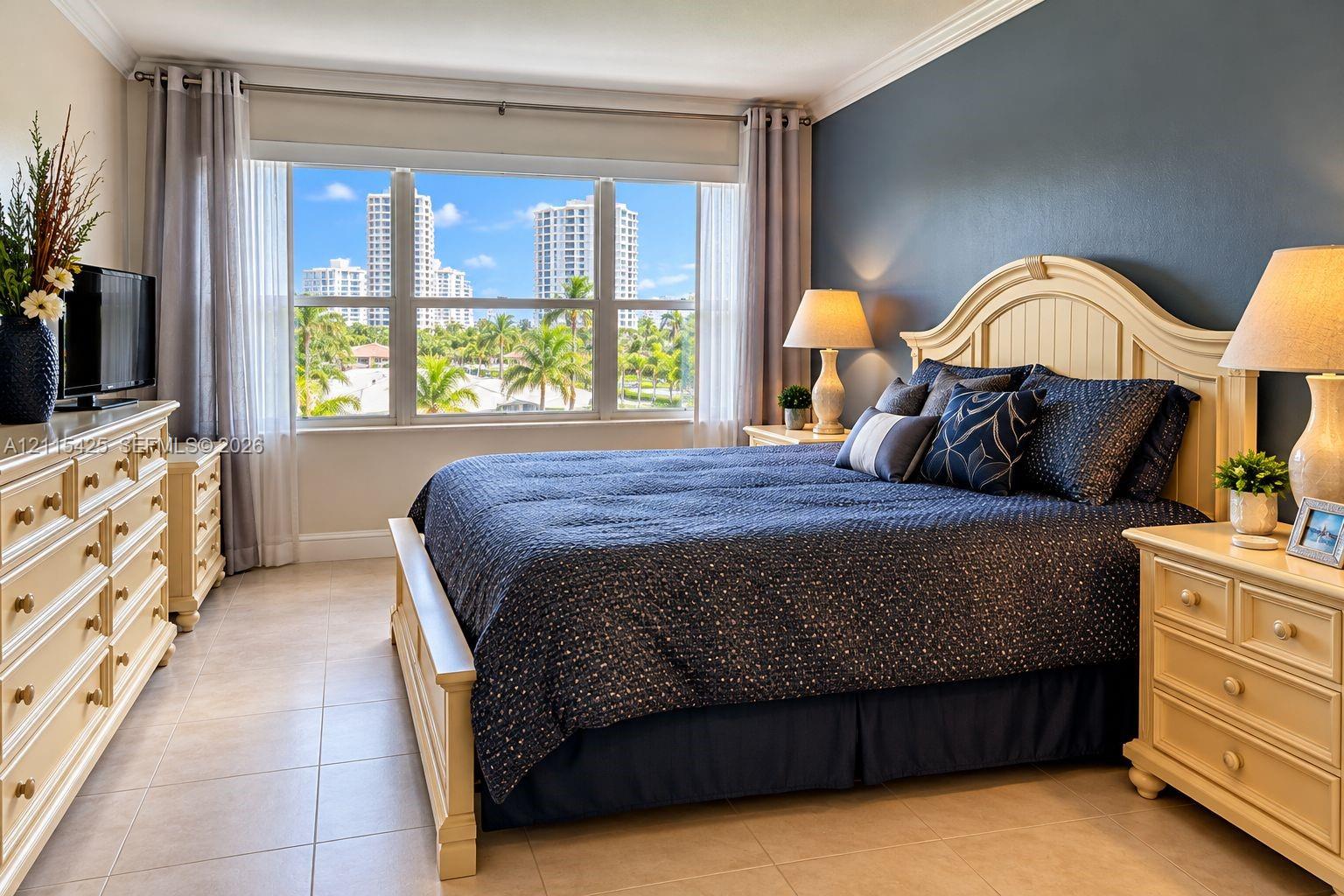 Bedroom featuring large multi-pane windows, crown molding, neutral tile flooring, and an accent wall