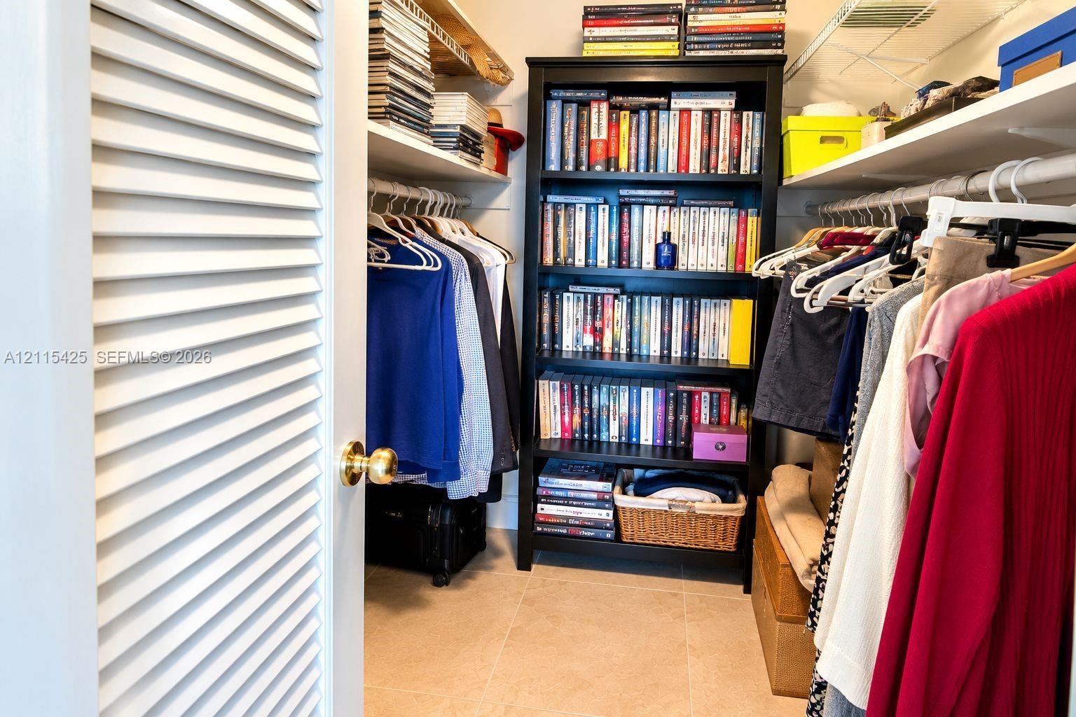 Storage area featuring louvered door access, white-coated wire shelving, and neutral-toned tile flooring