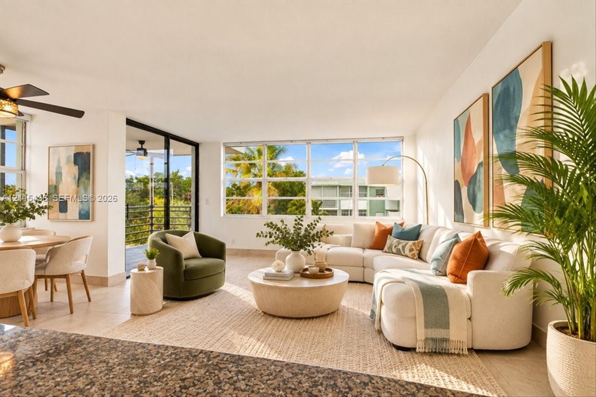 Open-concept interior featuring large-format tile flooring, oversized multi-pane windows, and a sliding glass door Open-concept interior featuring large-format tile flooring, oversized multi-pane windows, and a sliding glass door