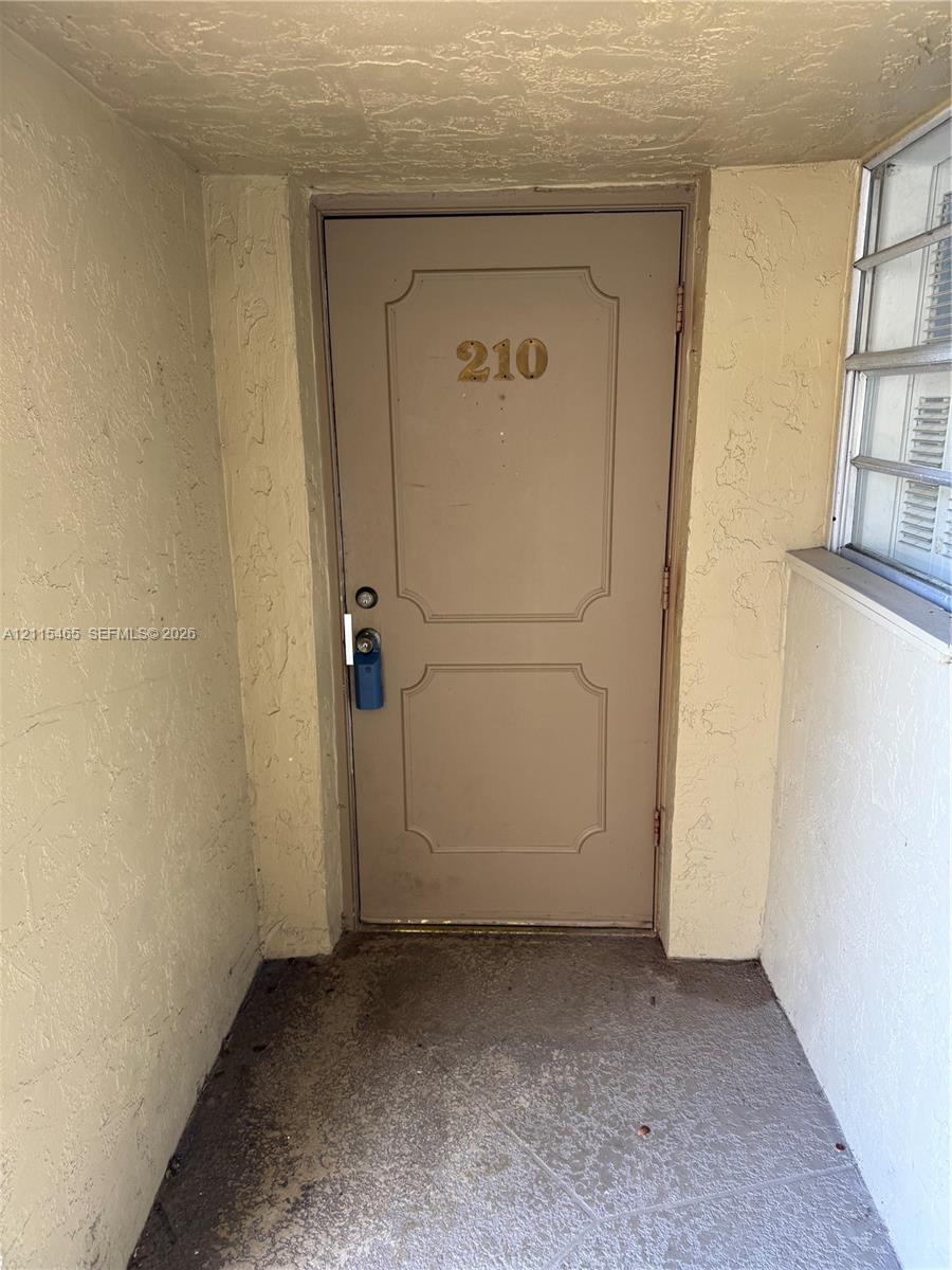 Entryway featuring a panelled door with metal hardware and an aluminum-framed window Entryway featuring a panelled door with metal hardware and an aluminum-framed window