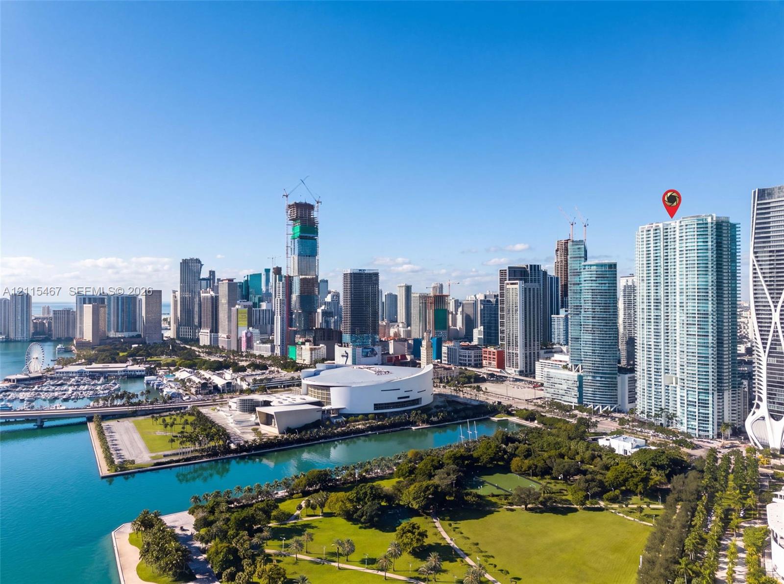 High-rise glass facade building featuring a prominent location within an expansive urban skyline, coastal proximity, and direct exposure to public waterfront green space