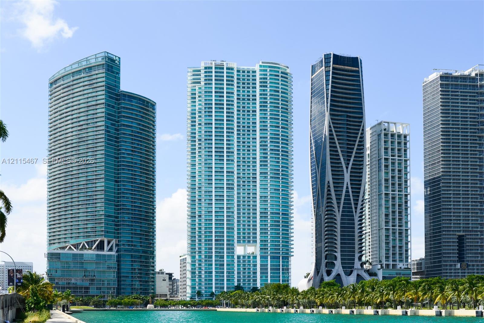 High-rise urban landscape featuring glass-facade skyscrapers, curvilinear architectural designs, and water-front proximity