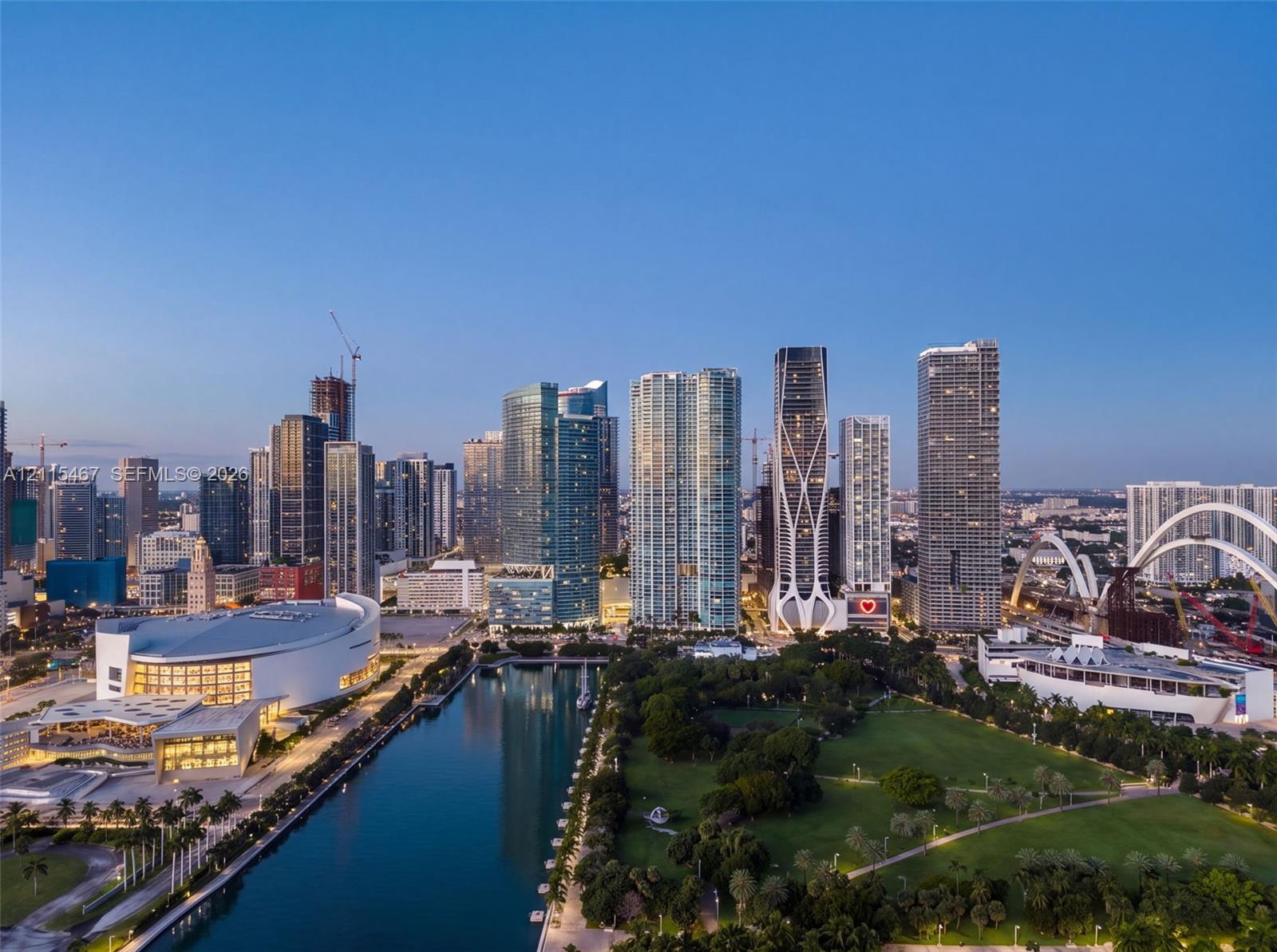 Aerial perspective of urban skyline featuring high-rise buildings, expansive public parkland, waterway, and large-scale architectural landmarks