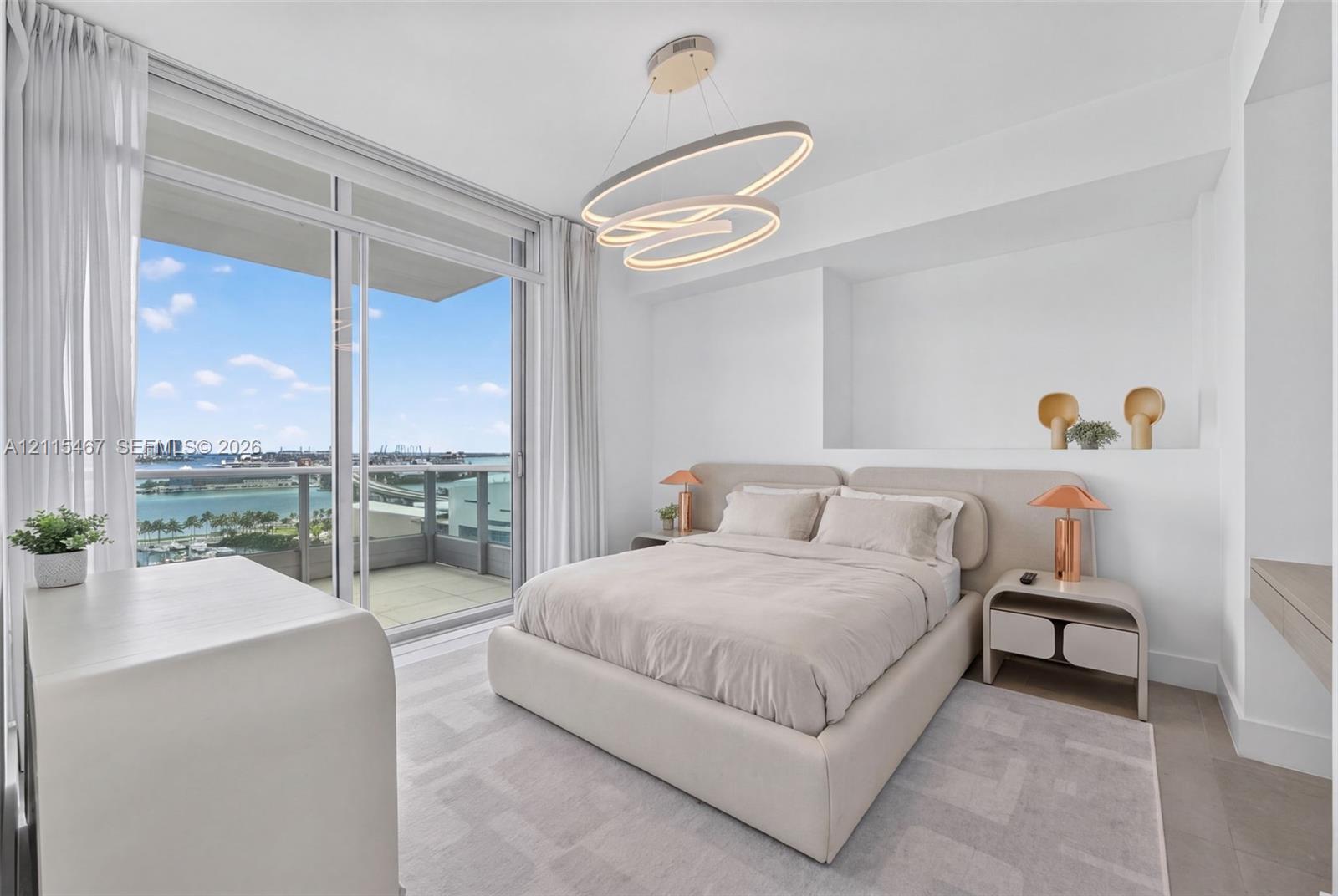 Floor-to-ceiling sliding glass door, private balcony, contemporary oval-shaped pendant lighting, and built-in wall niche