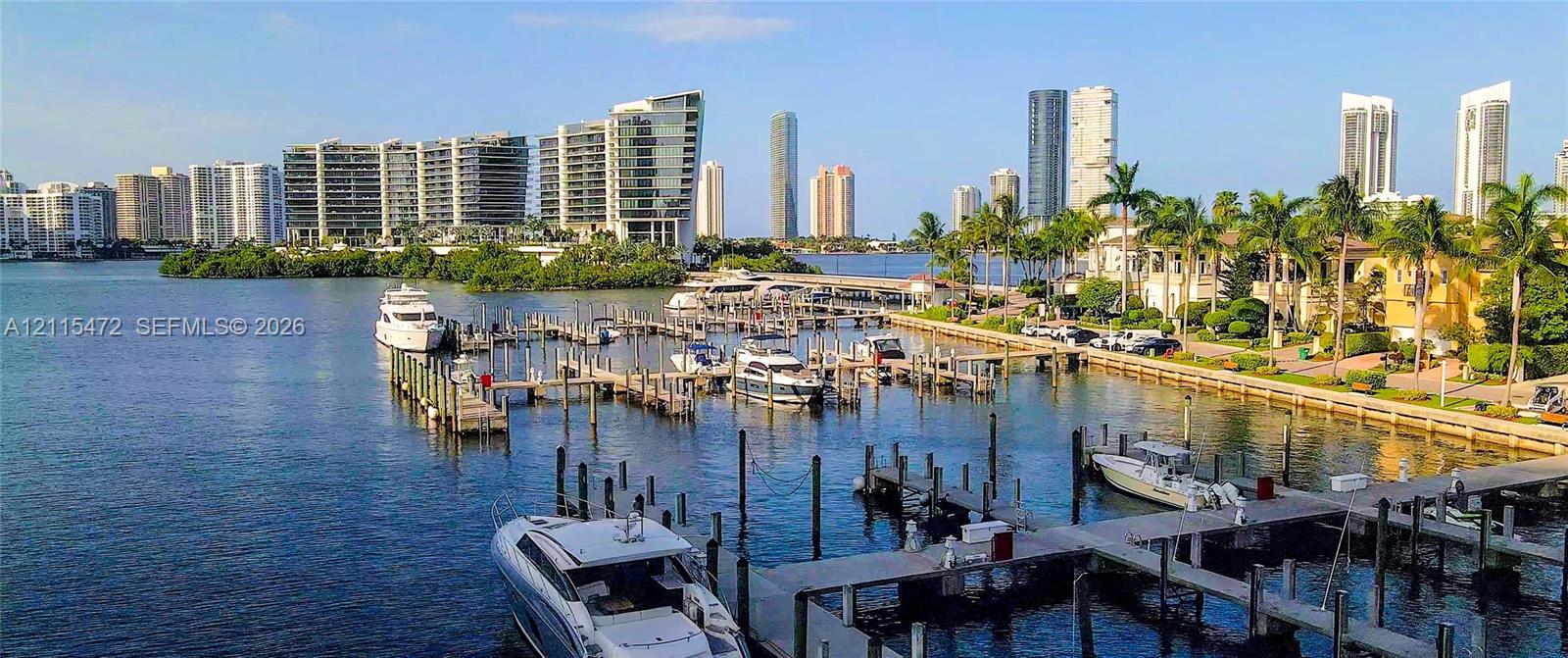 Waterfront marina featuring multiple deep-water boat slips, fixed wooden docks, and direct access to an expansive bay