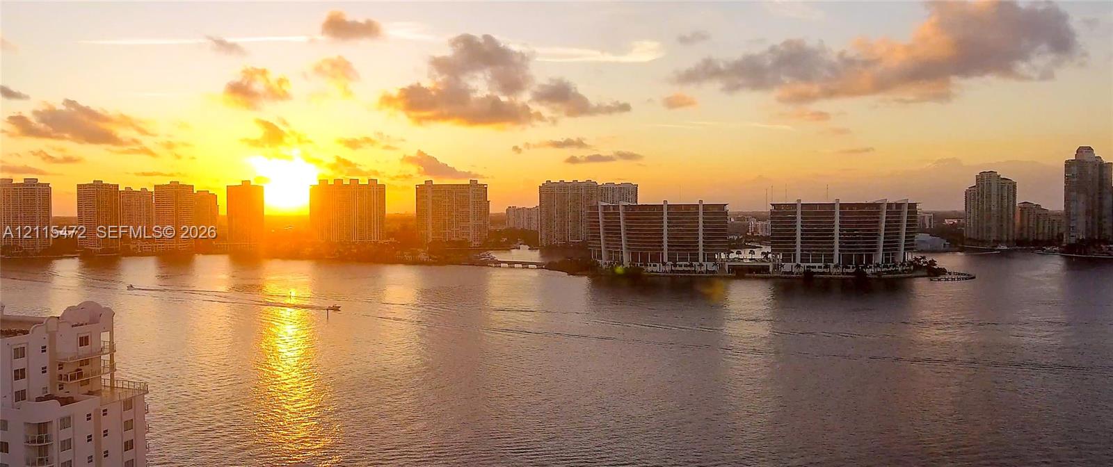 Aerial perspective of the waterway featuring high-rise architecture, expansive water frontage, and horizon skyline