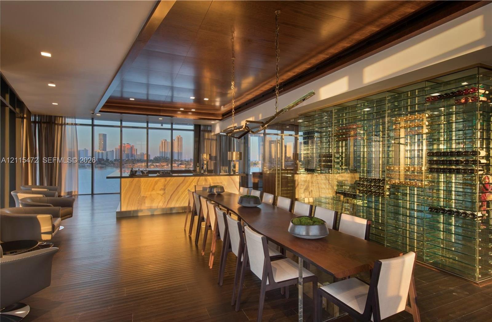 Floor-to-ceiling glass walls, expansive stone-front bar, temperature-controlled glass wine display, wood-finish flooring, and recessed ceiling lighting