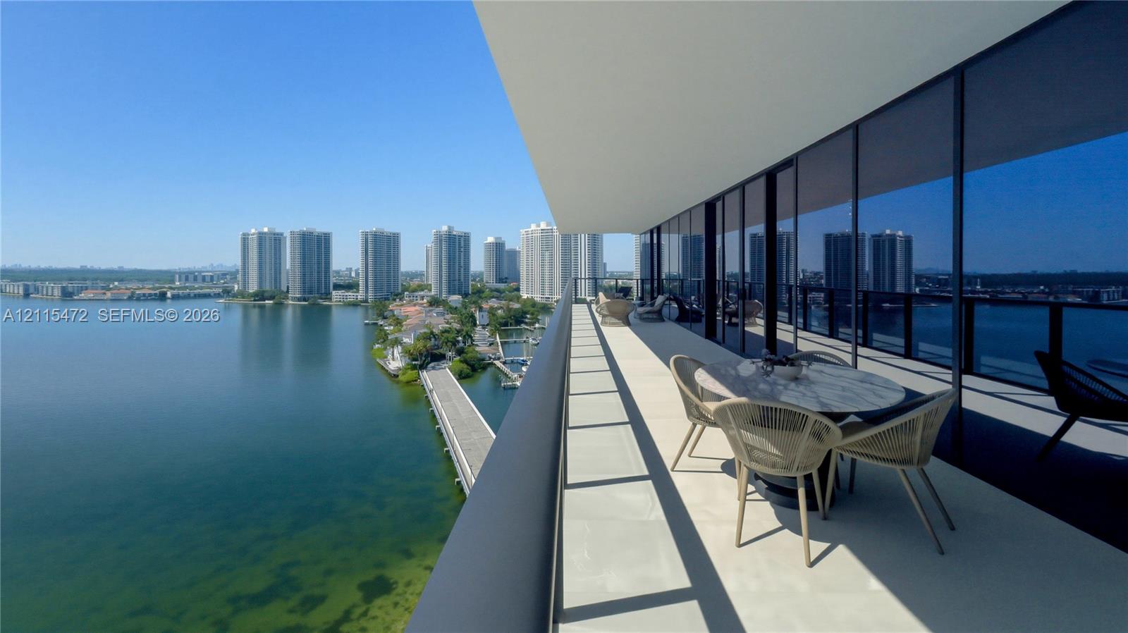 Expansive covered balcony featuring floor-to-ceiling glass paneling and a structural metal railing