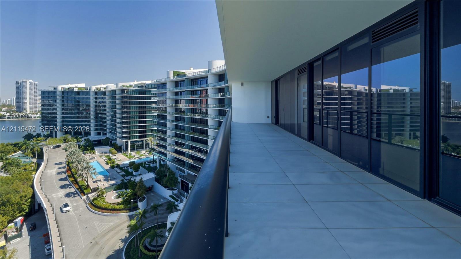 Covered balcony featuring oversized tile flooring, a metal railing, and floor-to-ceiling glass sliding doors