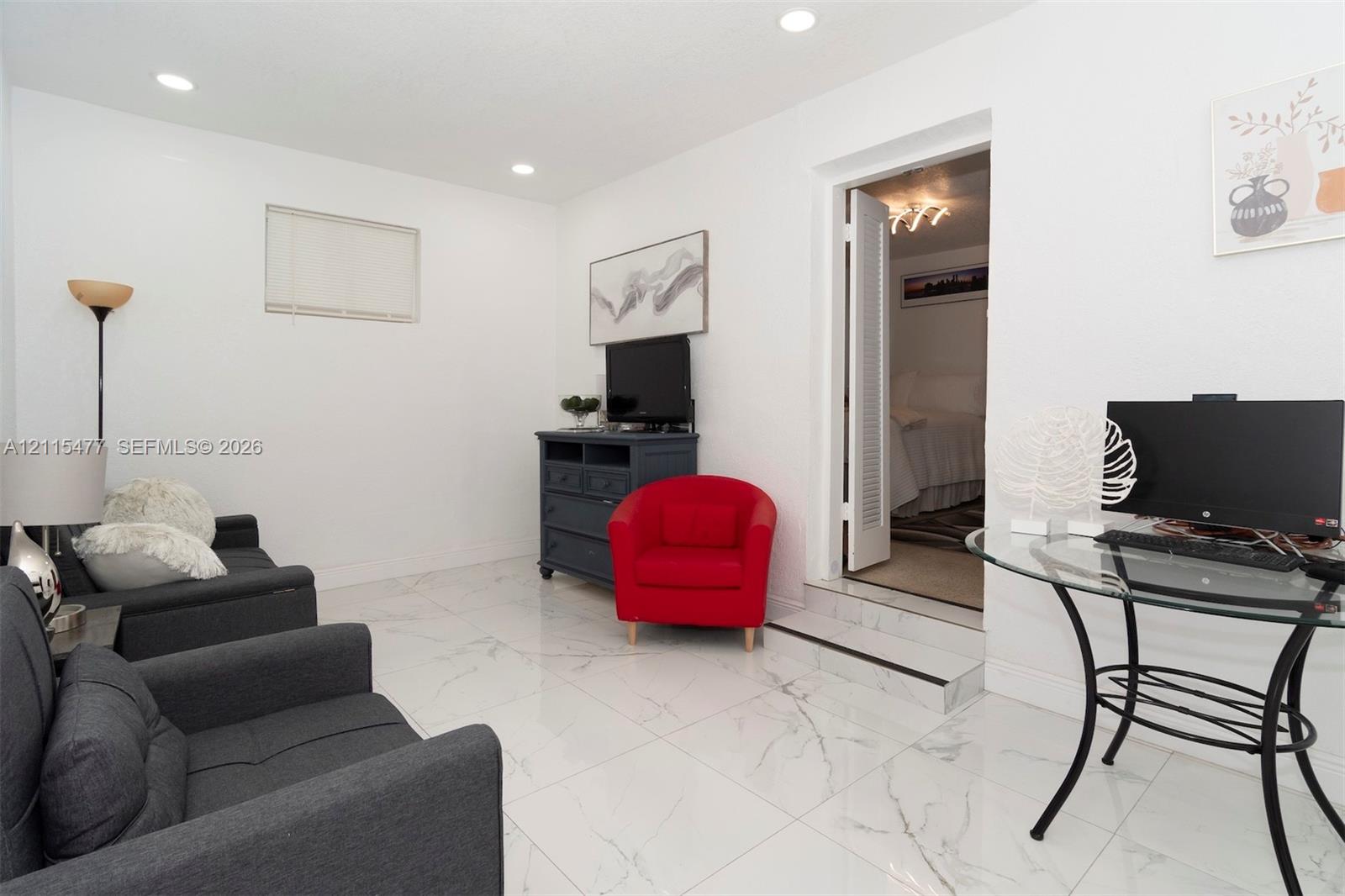 Polished stone-finish flooring with neutral veining, recessed lighting, and a single-step entry featuring a threshold trim