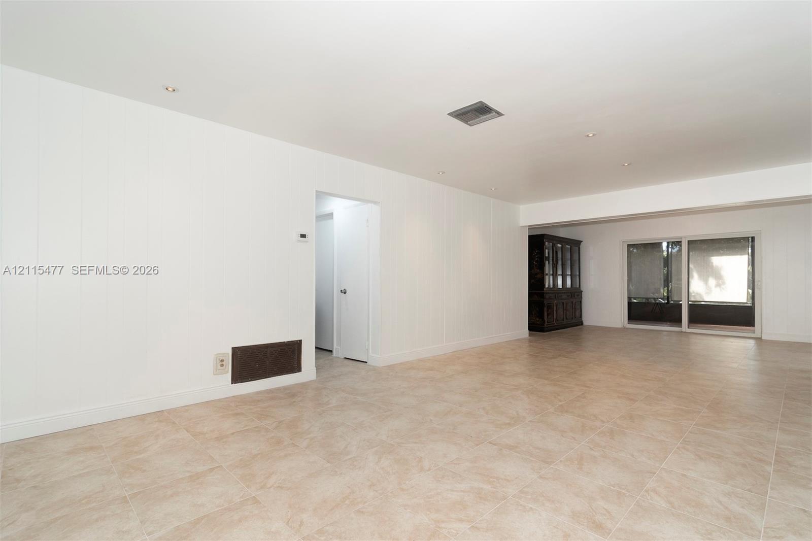 Neutral interior featuring tile flooring, recessed lighting, and sliding glass doors