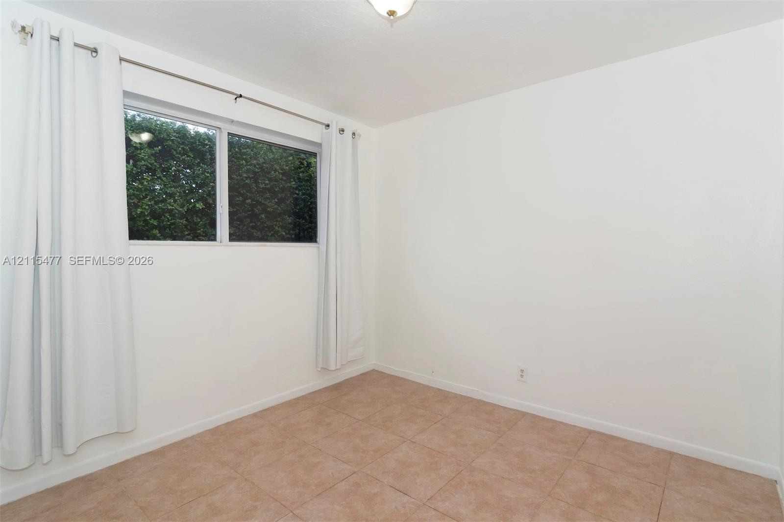 Neutral-toned ceramic tile flooring, clean white wall finishes, and a single-pane horizontal sliding window