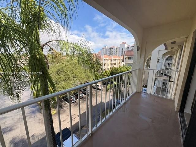 Covered balcony featuring white metal railings and arched architectural detailing