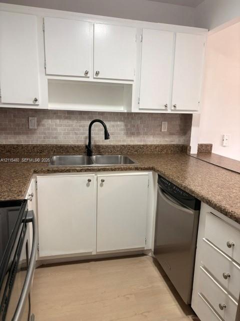 Kitchen featuring white cabinetry, speckled stone-finish countertops, brick-pattern backsplash, stainless steel dishwasher, and a matte black gooseneck faucet