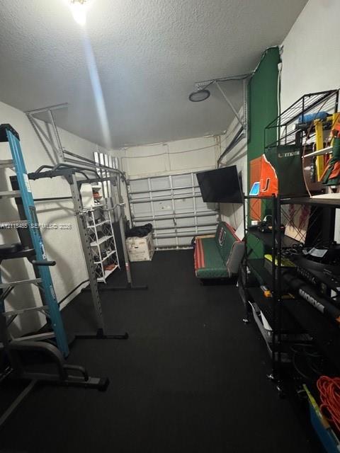 Garage space featuring a metal sectional door and solid flooring