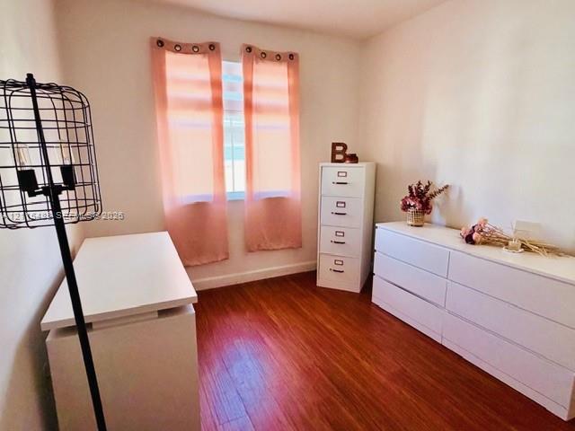 Room featuring wood-finish flooring, a single window, and neutral walls