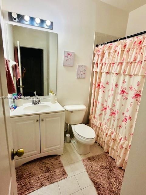 Bathroom featuring a white vanity cabinet with an integrated sink, a large wall-mounted mirror, four-bulb vanity lighting, and a bathtub with a shower enclosure