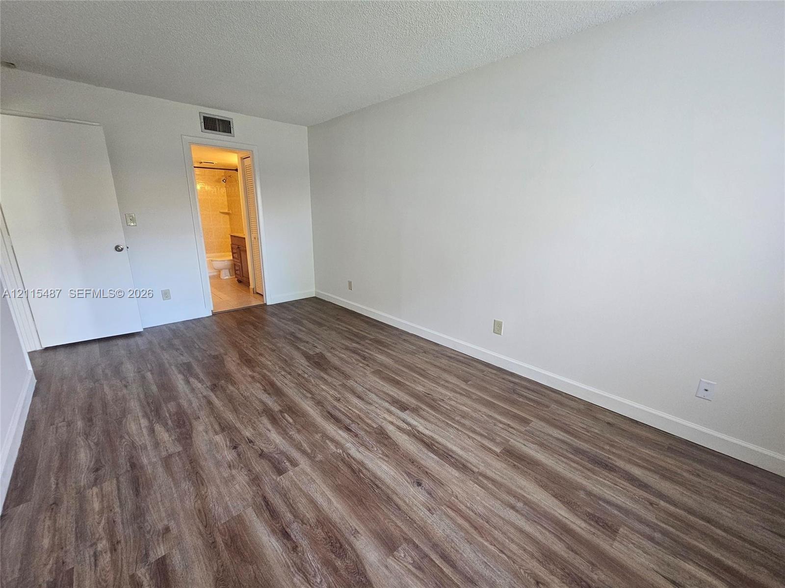 Room featuring wood-finish flooring and a neutral color palette