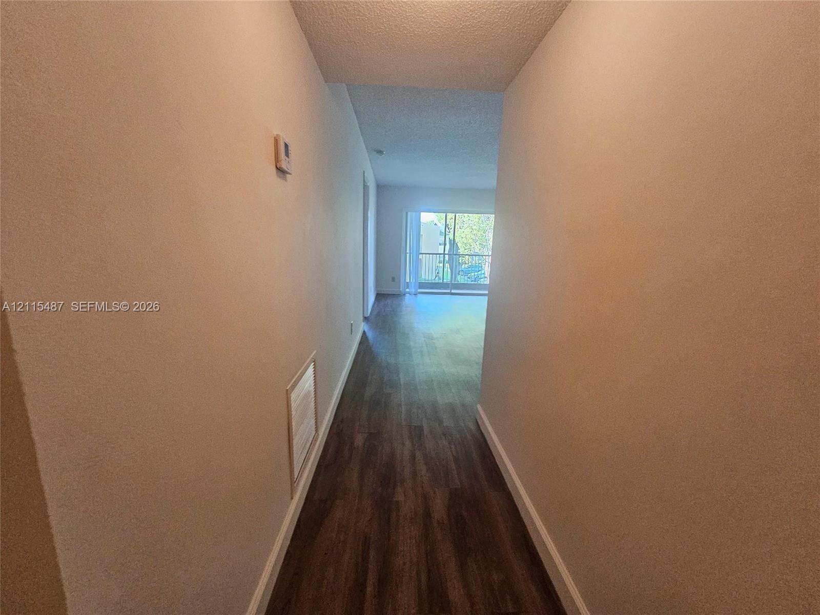 Hallway featuring wood-finish flooring and sliding glass doors