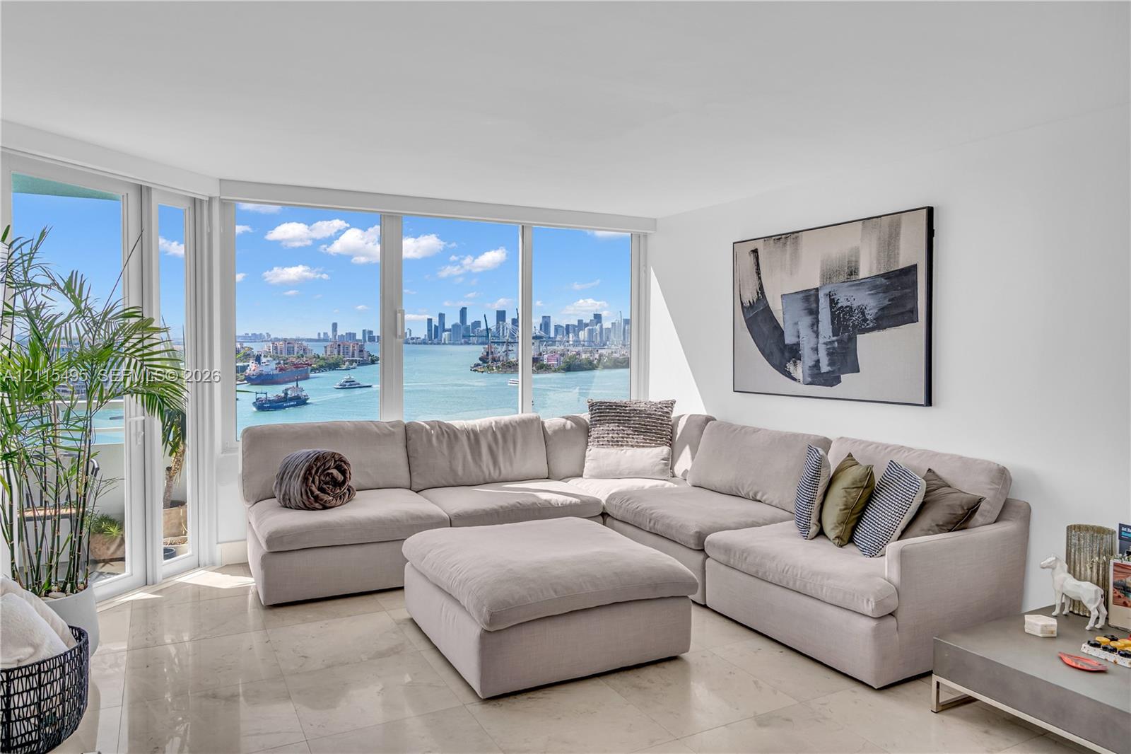 Floor-to-ceiling windows, natural stone flooring, and expansive water and city skyline outlooks