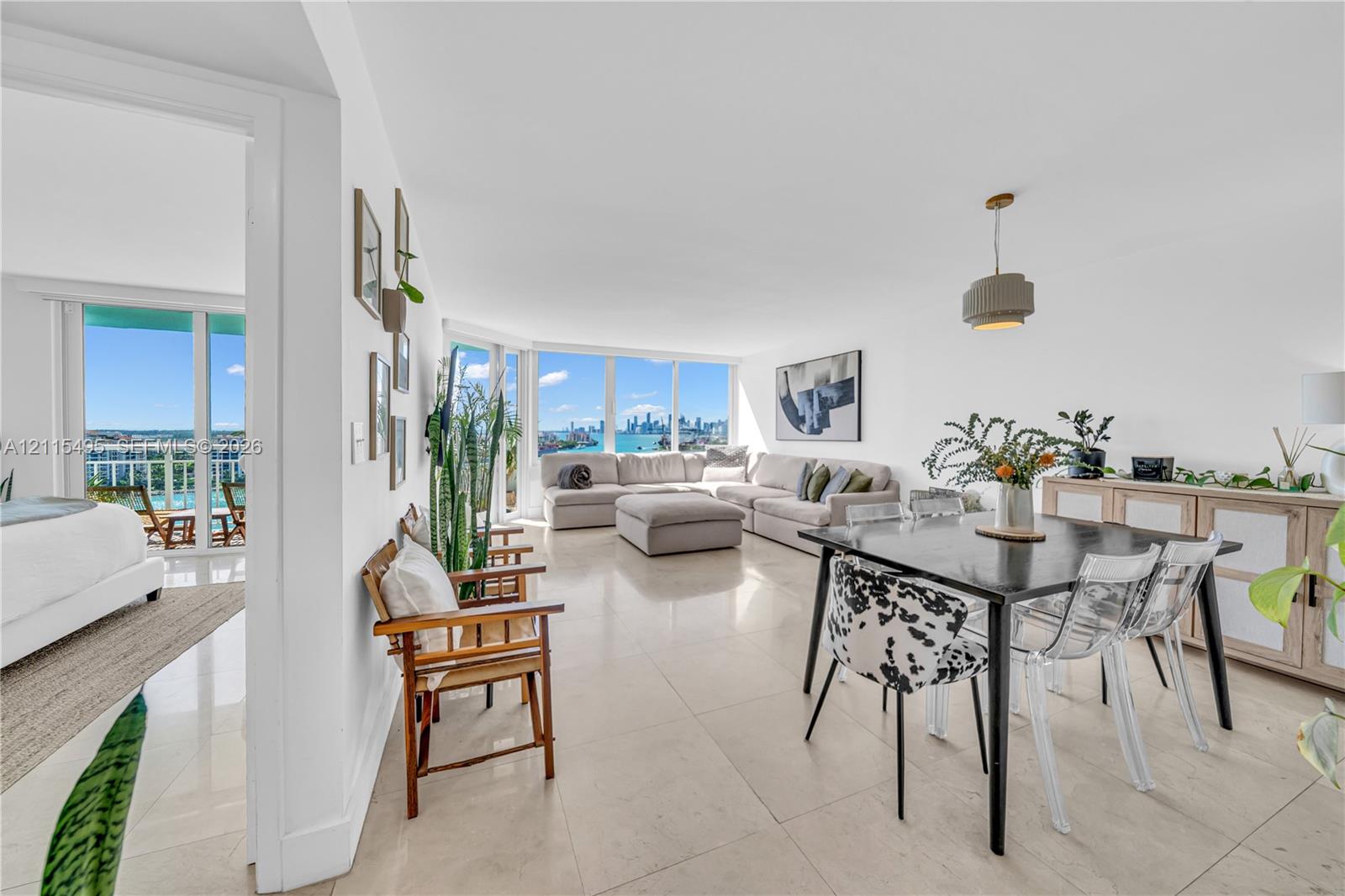 Open-concept living area featuring large-format tile flooring, expansive floor-to-ceiling windows, and a built-in sideboard