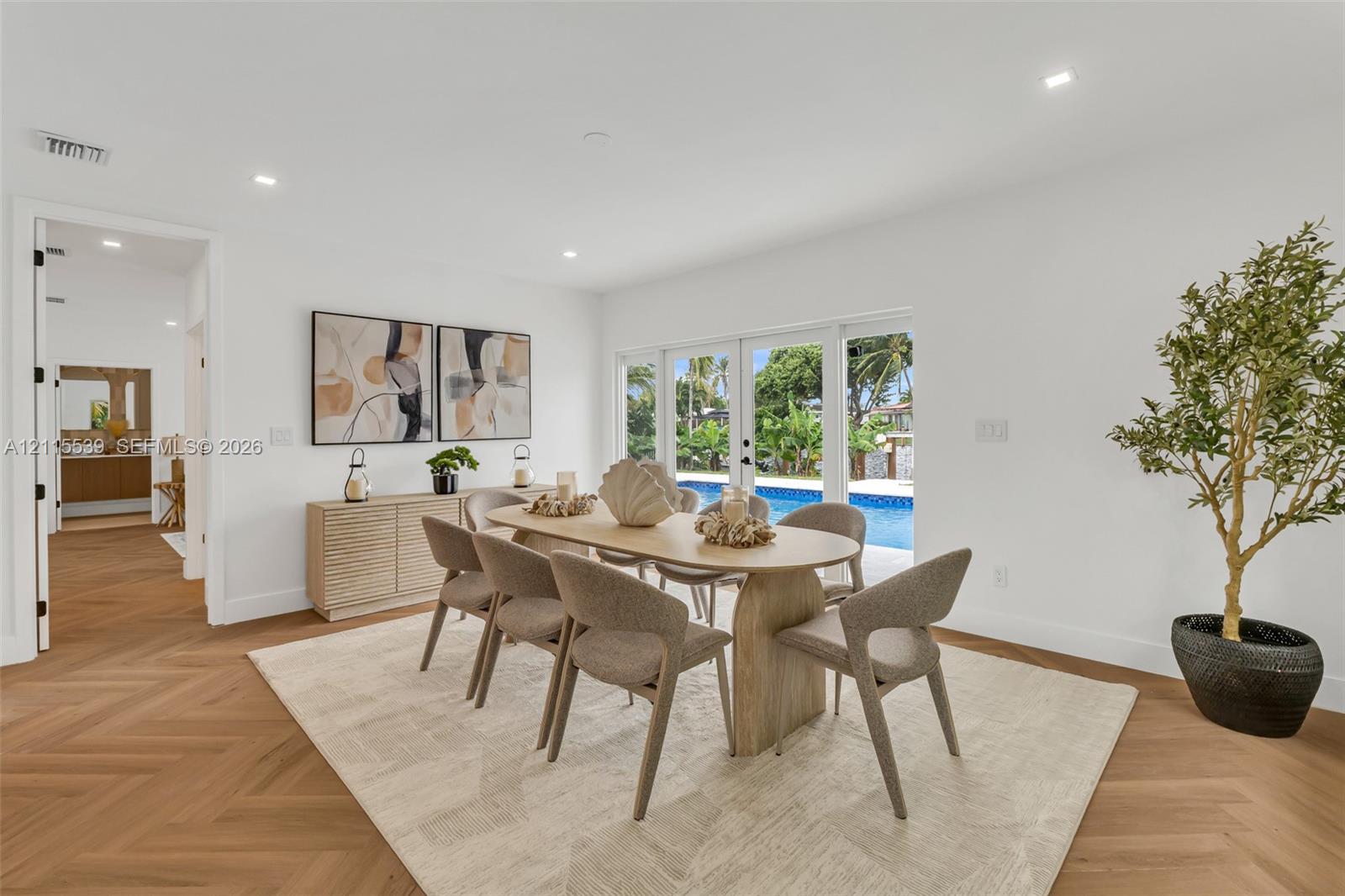 Herringbone-pattern wood-finish flooring, recessed lighting, and multi-panel glass exterior doors