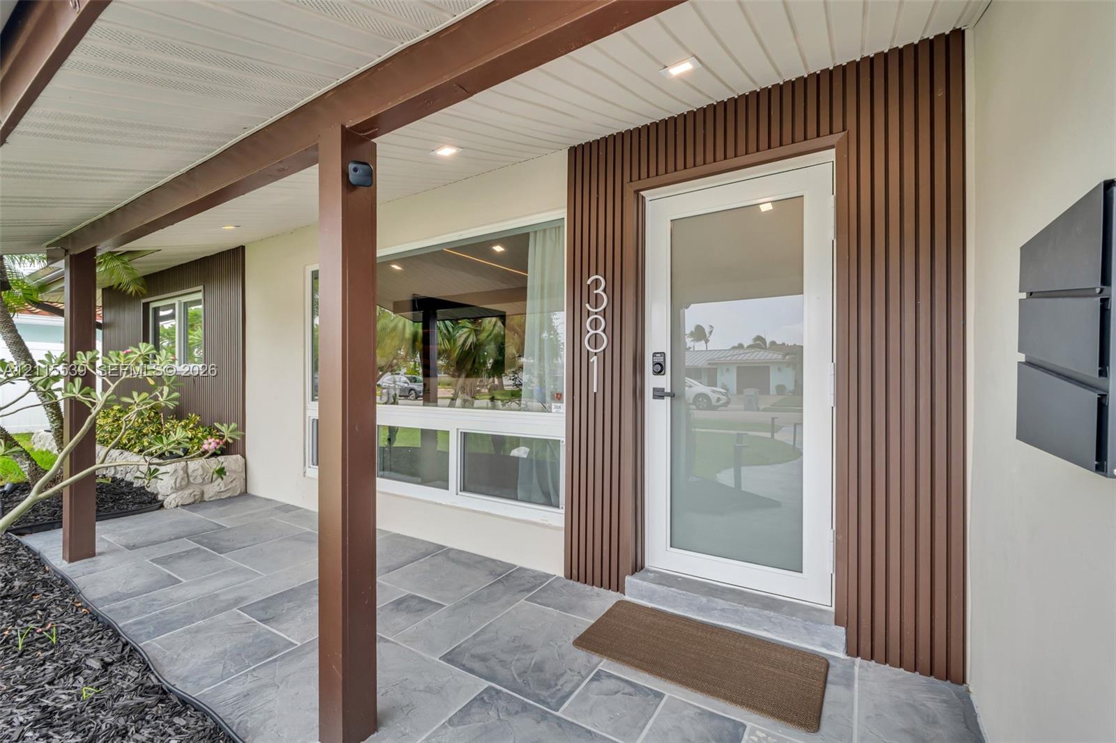 Two-car garage featuring a sectional overhead door, painted concrete flooring, white walls, and a dedicated exterior side-entry door