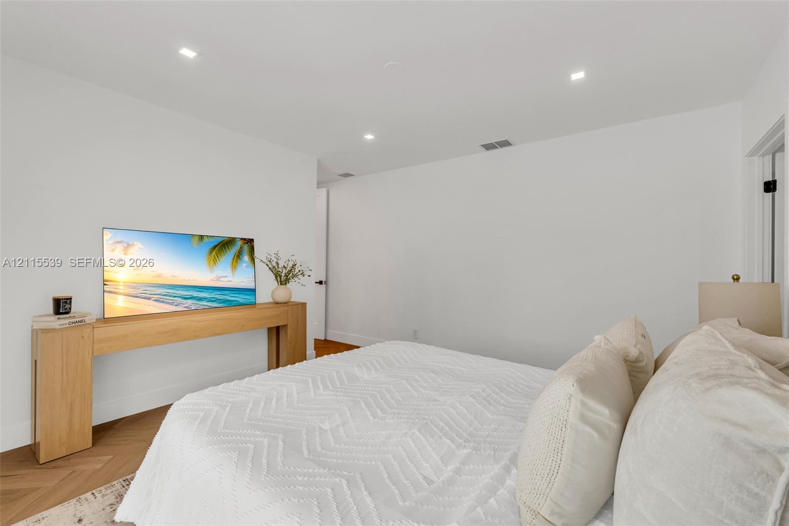 Room featuring herringbone wood-finish flooring and recessed lighting