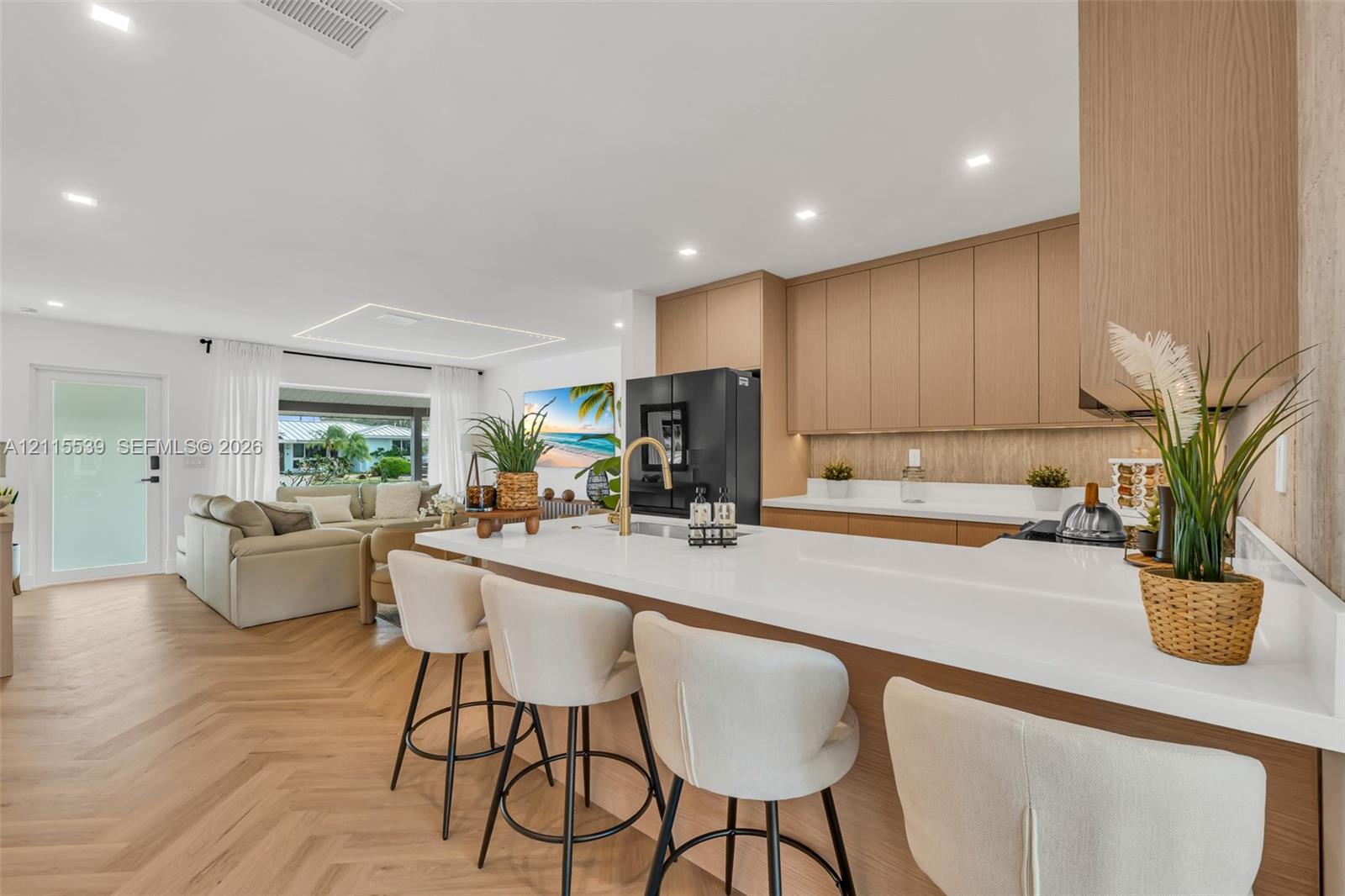 Kitchen featuring flat-panel wood cabinetry, white countertops, a gold-toned faucet, herringbone wood-finish flooring, and recessed ceiling lighting